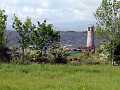 Blick vom Cottage auf Leuchtturm und Lough Corrib an einem windigen Tag